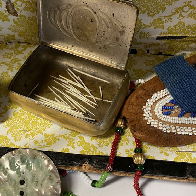 Tin box with porcupine quills, beaded child's moccasin, beaded necklace, button made from shell.