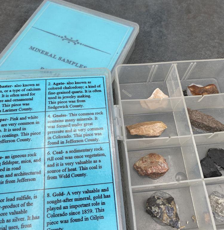Plastic box with mineral samples and card describing the contents.