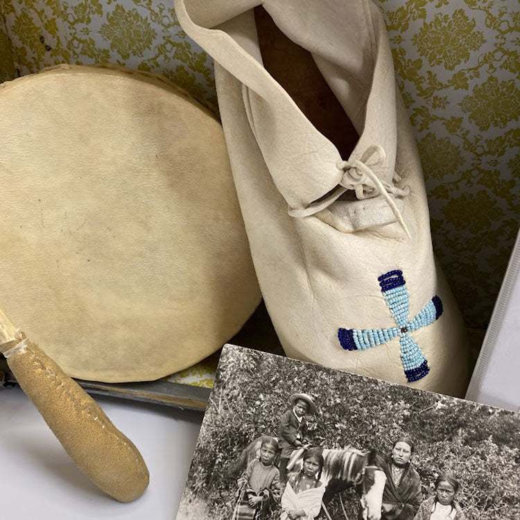 Buckskin drum and mallet, buckskin moccasin with beaded cross and photo pf American Indian family.
