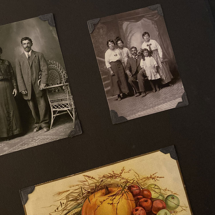 historic photos of family posed with three women standing, man seated and child standing with her hand on his knee. Displayed in photo album